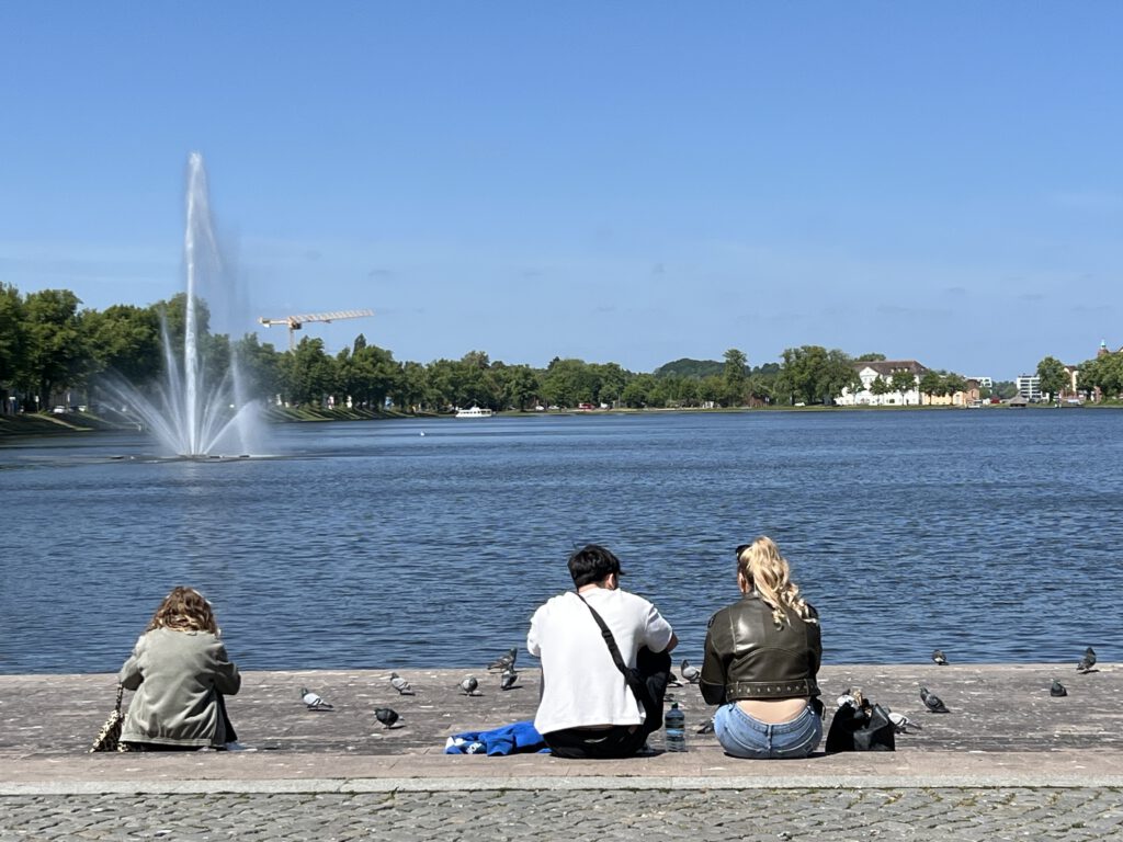 Menschen sitzen in der Sonne am Pfaffenteich