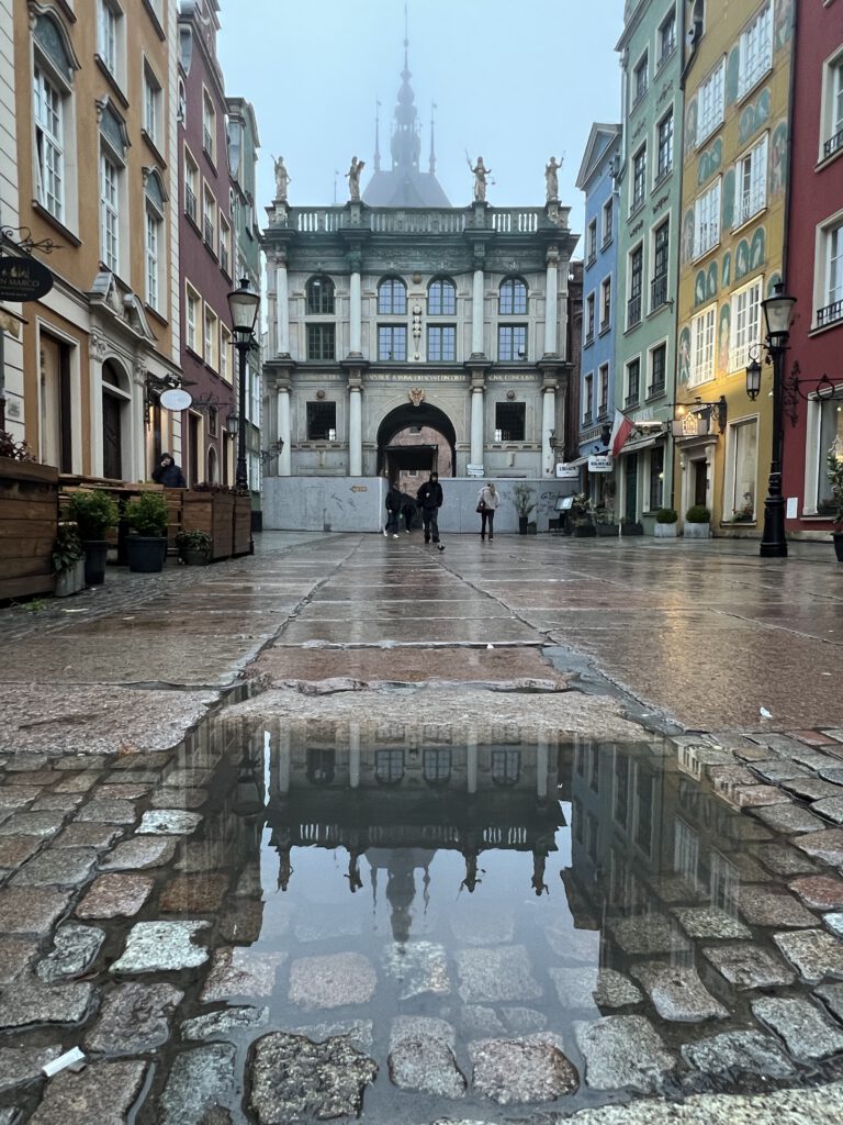 Goldenes Tor mit Spiegelung in Pfütze