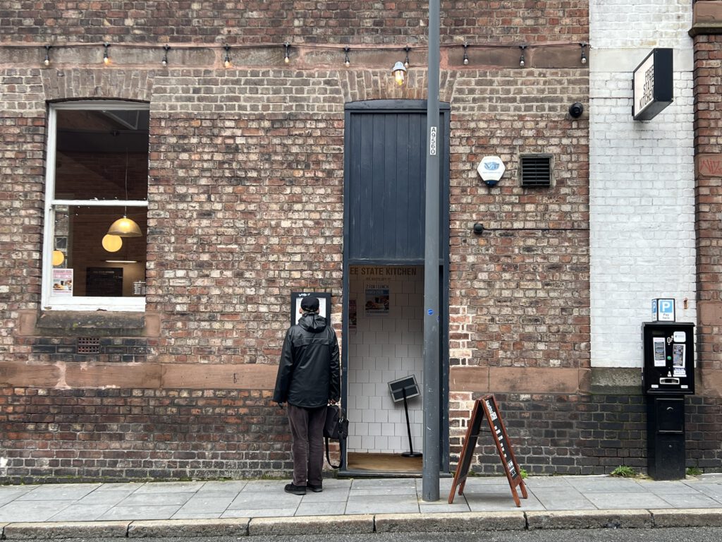 Mann vor einem Cafe in Liverpool